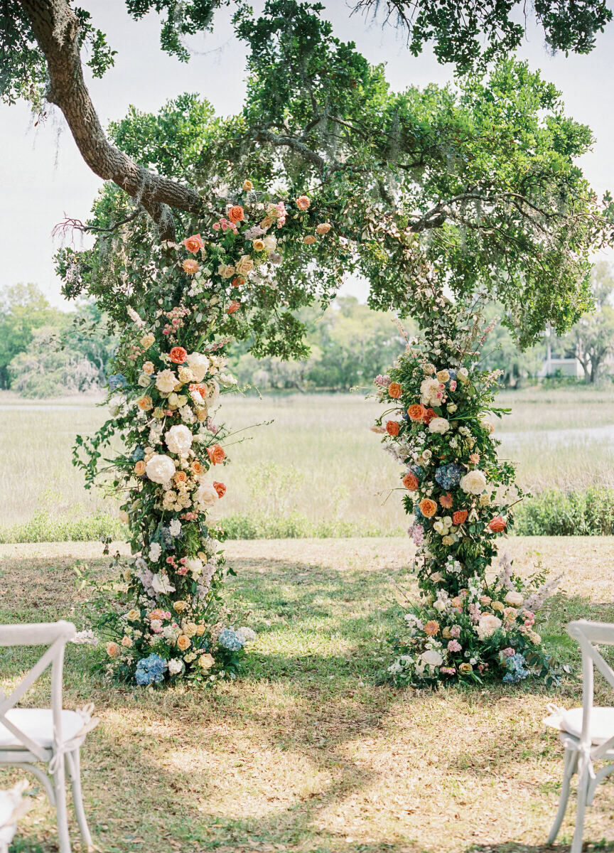 A colorful floral arch perfect for an elegant spring wedding incorporated pops of peach, pale blue, and soft yellows.