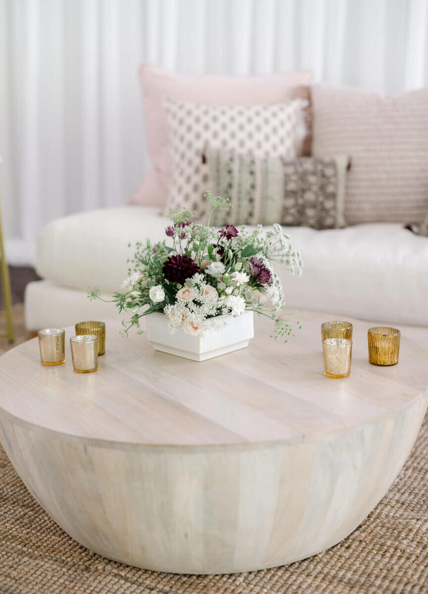 Modern lounge areas were decorated with glowing tea lights and modern floral arrangements at this elevated garden wedding reception in a tent.